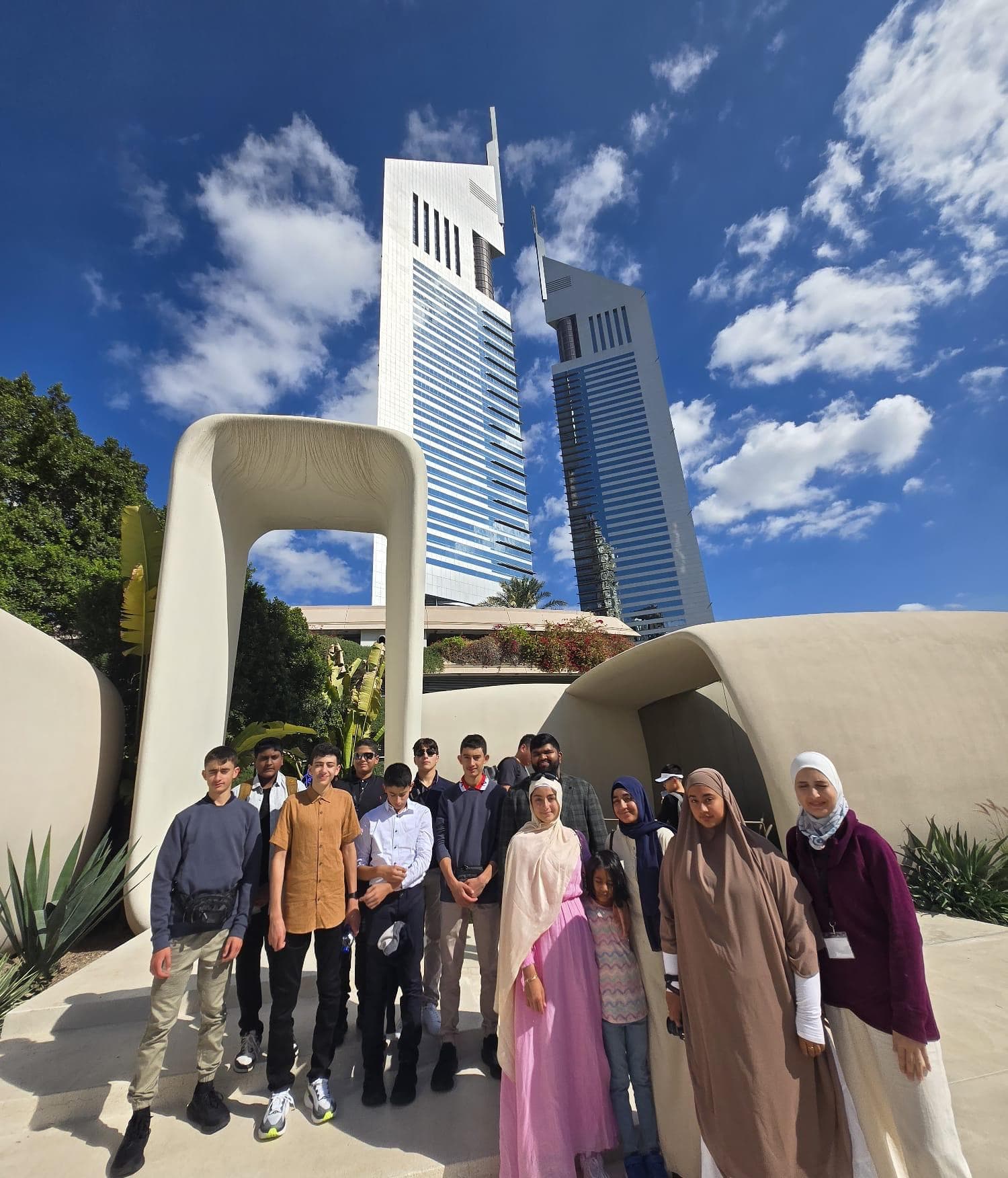 The group standing beneath the Emirates Towers on a sunny day